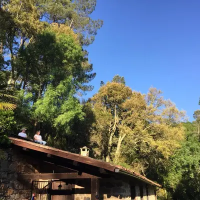 two people sitting on top of a wooden bridge at O Muíño da Balsiña in Tuiriz