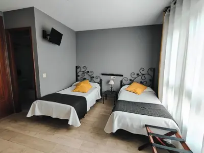 two beds with yellow pillows in a room at Nest El Camino in Santiago de Compostela