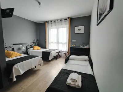 a room with two beds and a window at Nest El Camino in Santiago de Compostela