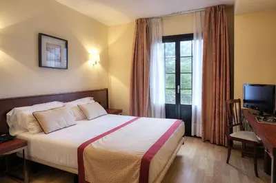 a hotel room with a bed and a window at Hotel y Apartamentos Arias in Navia