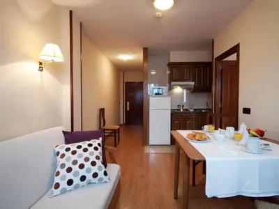 a kitchen and a living room with a table and a dining room at Hotel y Apartamentos Arias in Navia