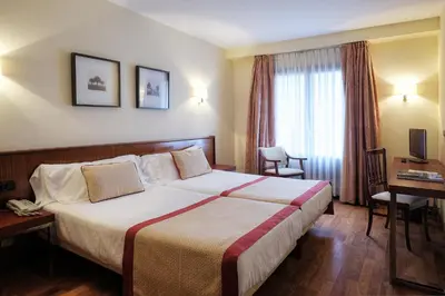 a hotel room with a large bed and a window at Hotel y Apartamentos Arias in Navia