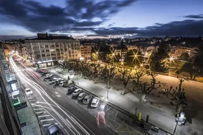a city street at night with cars parked at El apartamento de Ordes in Órdenes