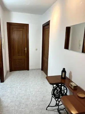 a room with a wooden table and a door at El apartamento de Ordes in Órdenes