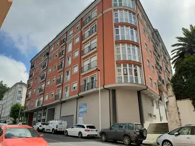 a large brick building with cars parked in front of it at Lazaro Sol in Viveiro