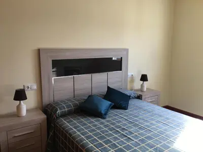 a bedroom with a bed with blue pillows on it at Lazaro Sol in Viveiro