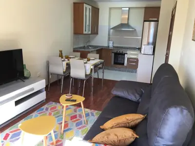 a living room with a couch and a kitchen at Lazaro Sol in Viveiro
