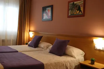 a hotel room with two beds with purple and white pillows at PENSIÓN RÚA in Arzúa