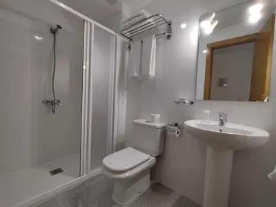 a bathroom with a toilet and a sink and a shower at PENSIÓN RÚA in Arzúa