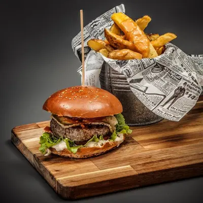 a hamburger and french fries on a cutting board at Blanco Hotel Spa in Navia