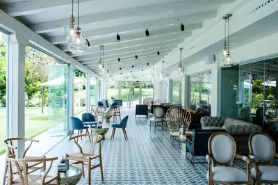 a room with chairs and tables and windows at Blanco Hotel Spa in Navia