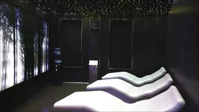 a room with four white chairs on a wall at Blanco Hotel Spa in Navia
