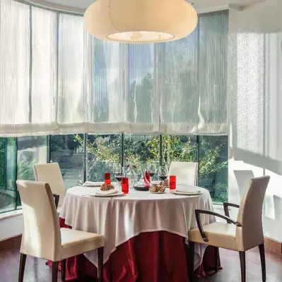 a dining room with a table and chairs and a large window at Blanco Hotel Spa in Navia
