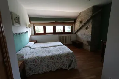 a bedroom with two beds and a window at Casa Grande da Capellania in Padrón