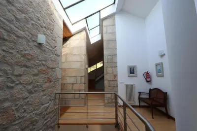 a staircase with a stone wall and a skylight at Casa Grande da Capellania in Padrón
