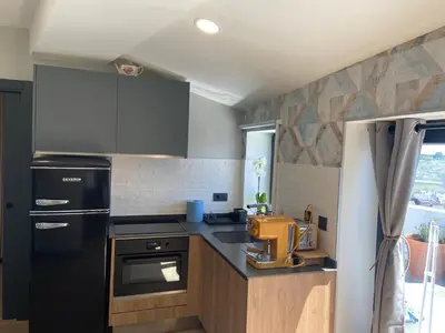 a kitchen with a black refrigerator and a sink at Siente Muralla in Lugo
