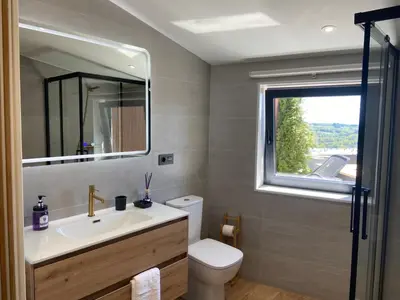 a bathroom with a sink and a toilet and a window at Siente Muralla in Lugo