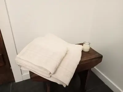 a stack of white towels sitting on a wooden table at A Casiña da Ponte in Padrón