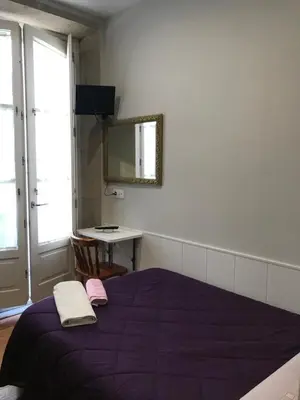 a bedroom with a purple bed and a mirror at PR Paz de Agra in Santiago de Compostela
