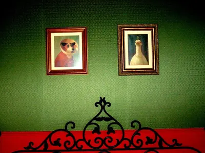 a green wall with two pictures of a dog and a bed at Hotel Mi Norte in Ribadeo