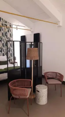 a room with two chairs and a lamp and a bed at Hotel Rural O Cruce do Burgo in Friol