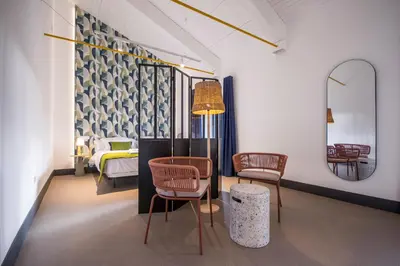 a room with two chairs and a bed and a mirror at Hotel Rural O Cruce do Burgo in Friol