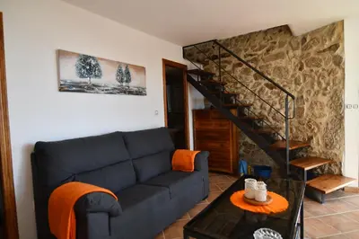 a living room with a blue couch and a staircase at Casa Avoa María in Ourense