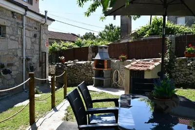 a patio with a table and chairs and an umbrella at Casa Avoa María in Ourense