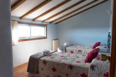 a bedroom with two beds and a window at Casa Avoa María in Ourense