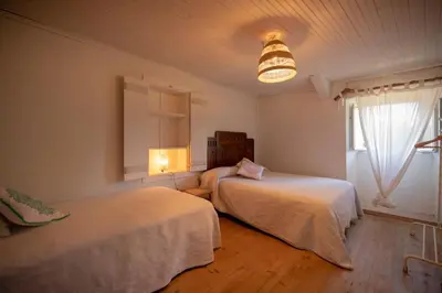 a bedroom with two beds and a window at Casa O Coto in Grañas