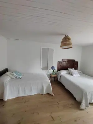 a white room with two beds and a lamp at Casa O Coto in Grañas