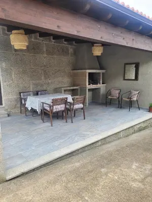 a patio with a table and chairs and a stove at Casa do Porto in Partovia