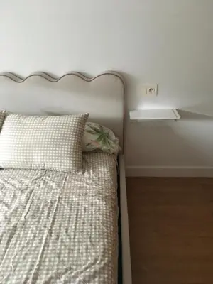 a bedroom with a bed with a pillow and a shelf at Alquiler de piso nuevo in Burela de Cabo