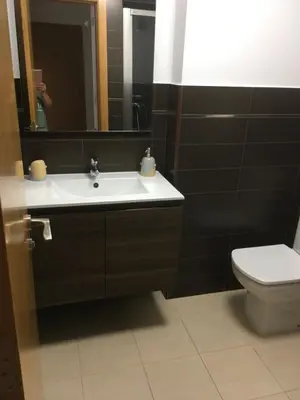 a bathroom with a sink and a toilet and a mirror at Alquiler de piso nuevo in Burela de Cabo