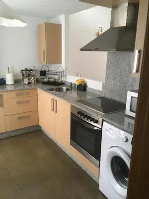 a kitchen with a washing machine and a washer at Alquiler de piso nuevo in Burela de Cabo