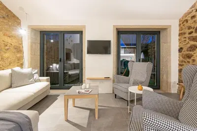 a living room with a couch and chairs and a table at A casa de Abaixo, aloxamento rural in Vedra