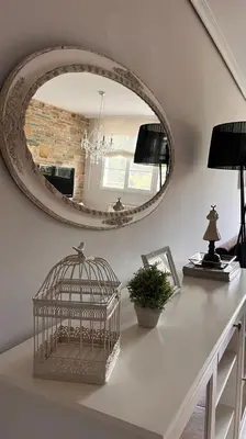 a white counter with a mirror and a bird cage at BenedettaMolinaseca VuT in Molinaseca
