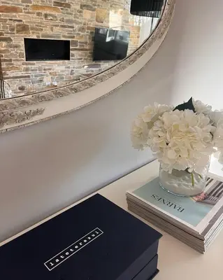 a table with a vase of flowers and a mirror at BenedettaMolinaseca VuT in Molinaseca