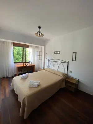 a bedroom with a bed with two towels on it at Piso grande y muy luminoso in Santiago de Compostela