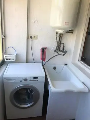a small bathroom with a washing machine and a sink at Piso grande y muy luminoso in Santiago de Compostela