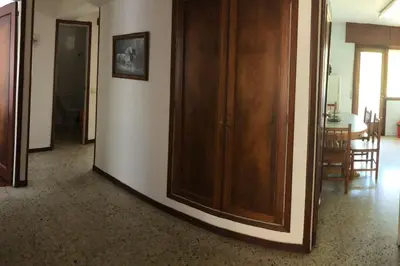 a hallway with wooden cabinets and a dining room at Piso grande y muy luminoso in Santiago de Compostela