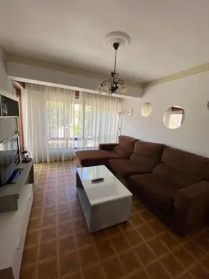 a living room with a brown couch and a coffee table at Piso grande y muy luminoso in Santiago de Compostela