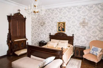 a bedroom with a bed and two chairs and a chandelier at Hotel Monumento Pazo do Castro in O Barco de Valdeorras