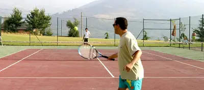 two men playing tennis on a tennis court at Hotel Monumento Pazo do Castro in O Barco de Valdeorras