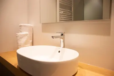 a white sink in a bathroom with a mirror at Apartamentos Lucio Rodinso in Castroverde