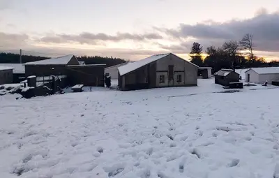 a snow covered yard with a house and buildings at Apartamentos Lucio Rodinso in Castroverde