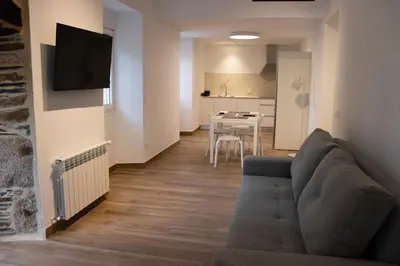 a living room with a couch and a dining room at Apartamentos Lucio Rodinso in Castroverde