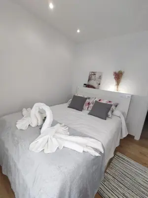 a white bed with white towels on it at Gallaecia in Arzúa