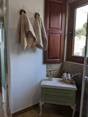 a bathroom with a green cabinet and towels hanging on the wall at El cobijo de Soar ¡Casa rural completa! in Moraña