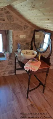 a vanity with a mirror on a table in a room at El cobijo de Soar ¡Casa rural completa! in Moraña